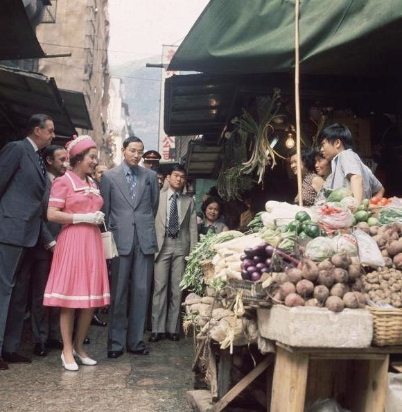 1975年英女皇第一次到訪香港，在港督陪同下參觀中環嘉咸街街市。（維基百科）