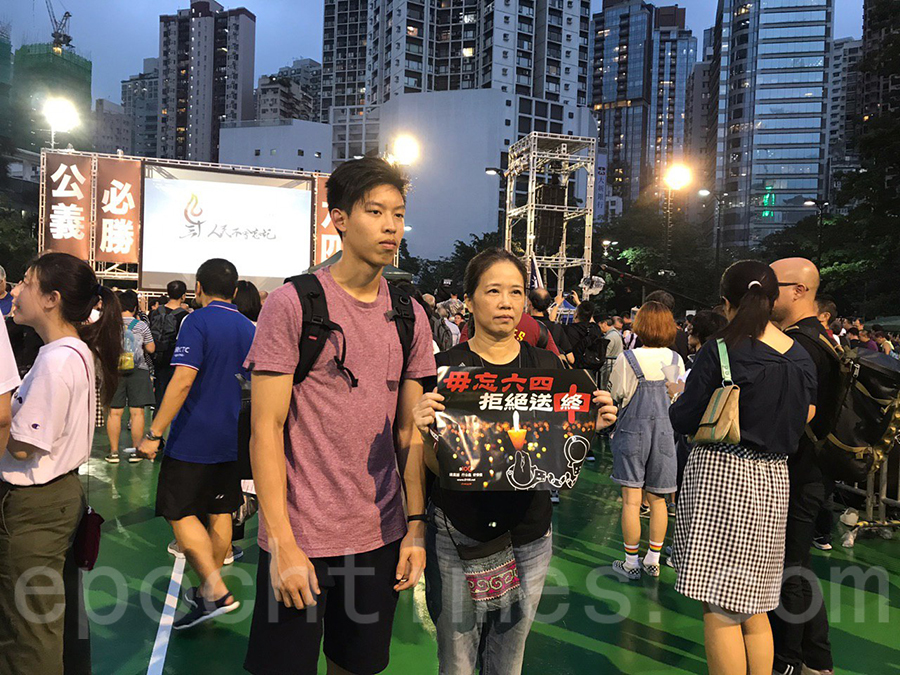 有市民拿着寫上「毋忘六四，拒絕送中」的標語。（林儀／大紀元）