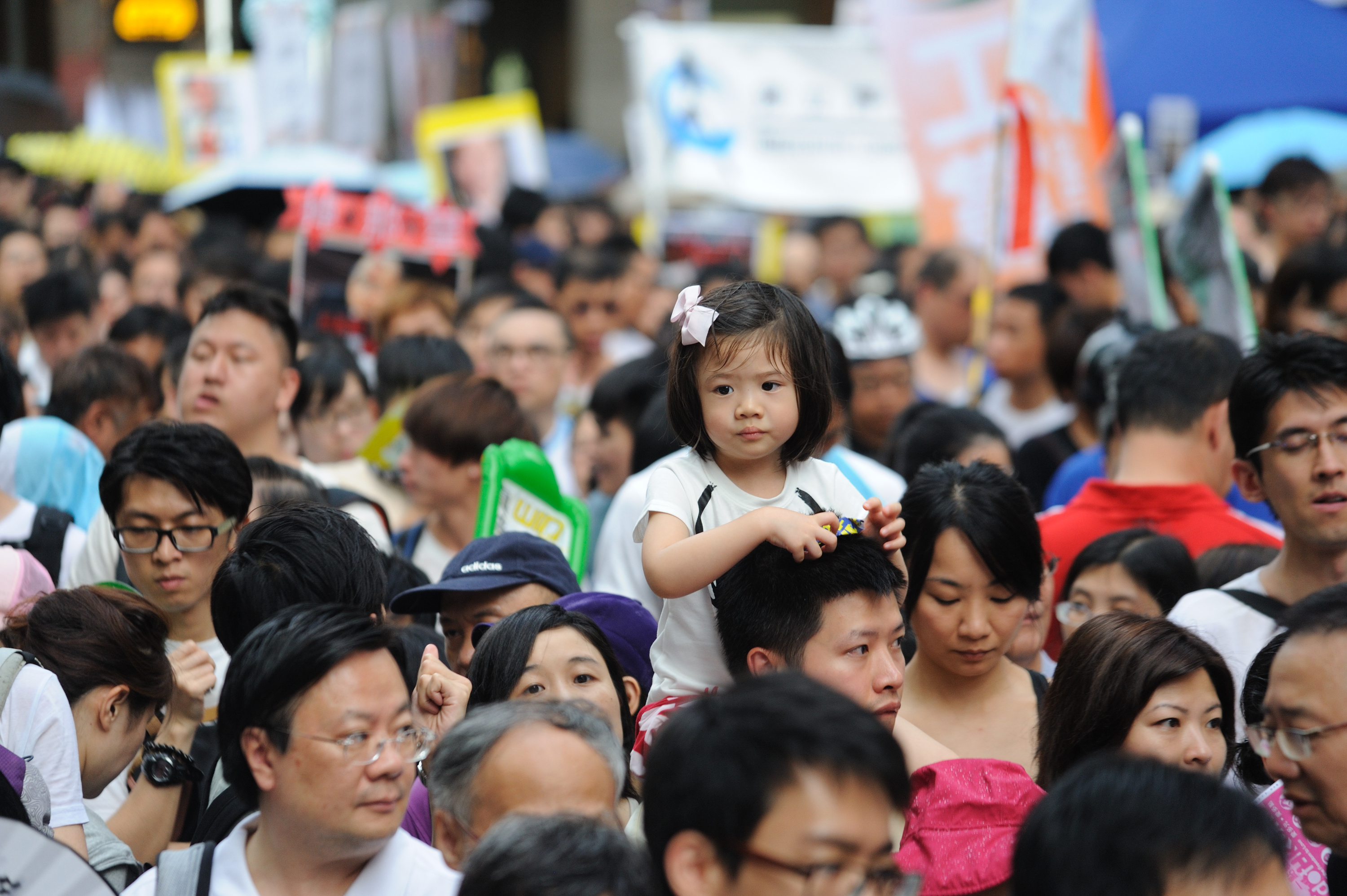 2014年7.1香港大遊行。遊行隊伍裏的小女孩，騎在爸爸的脖子上，可以俯視遊行隊伍。（文瀚林／大紀元）