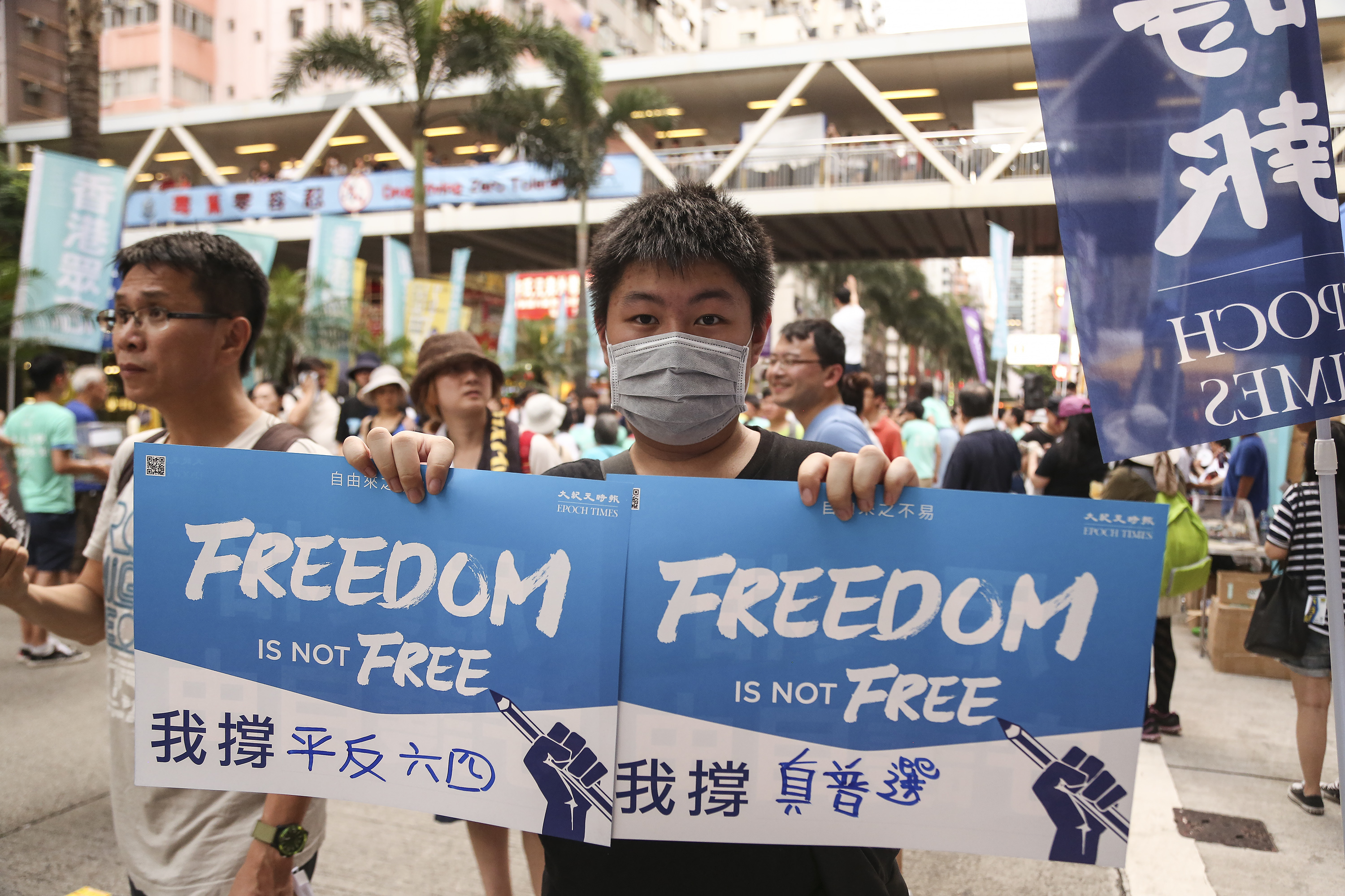 2016香港七一大遊行，逾11萬市民無懼酷暑走上街頭表達對梁振英不滿，有市民寫下訴求。（余鋼/大紀元）