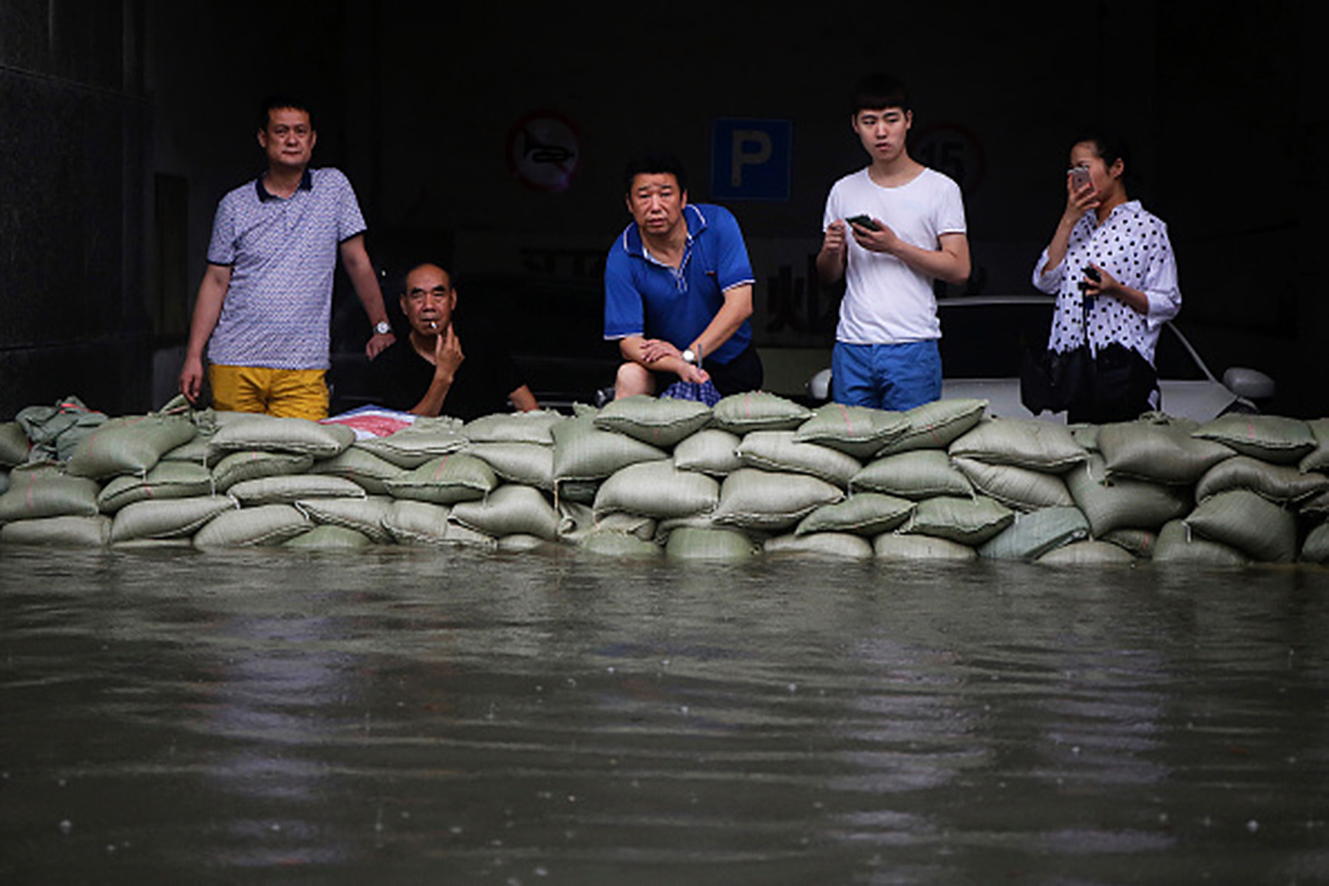 7月6日武漢居民經歷暴雨襲擊後，站在沙包後面一臉茫然。（Wang He/Getty Images)
