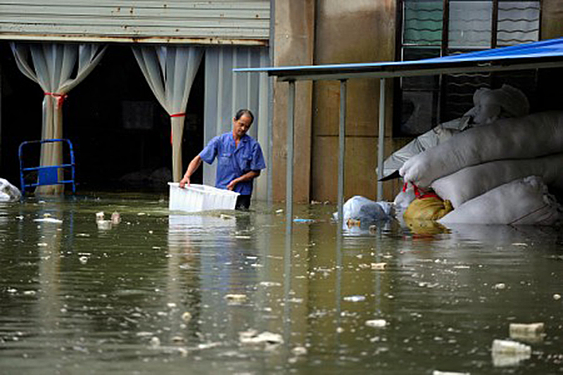 7月5日，安徽省一名男子在淹水區行走。（STR/AFP/Getty Images)