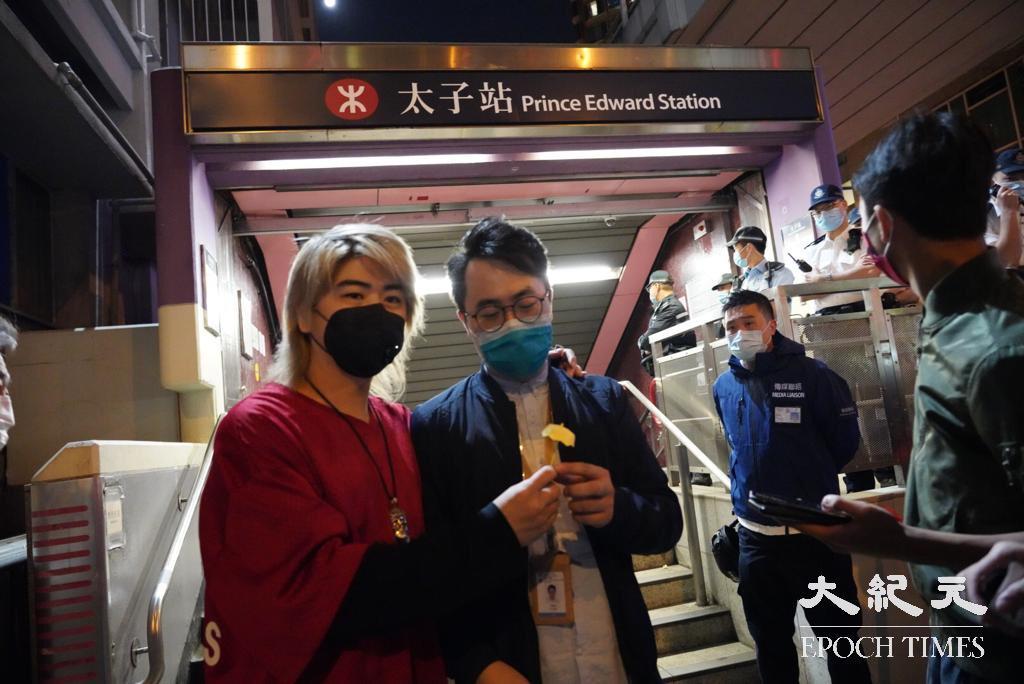 歌星阮民安（左）和油尖旺區議員林兆彬在太子站鮮花（余鋼／大紀元）