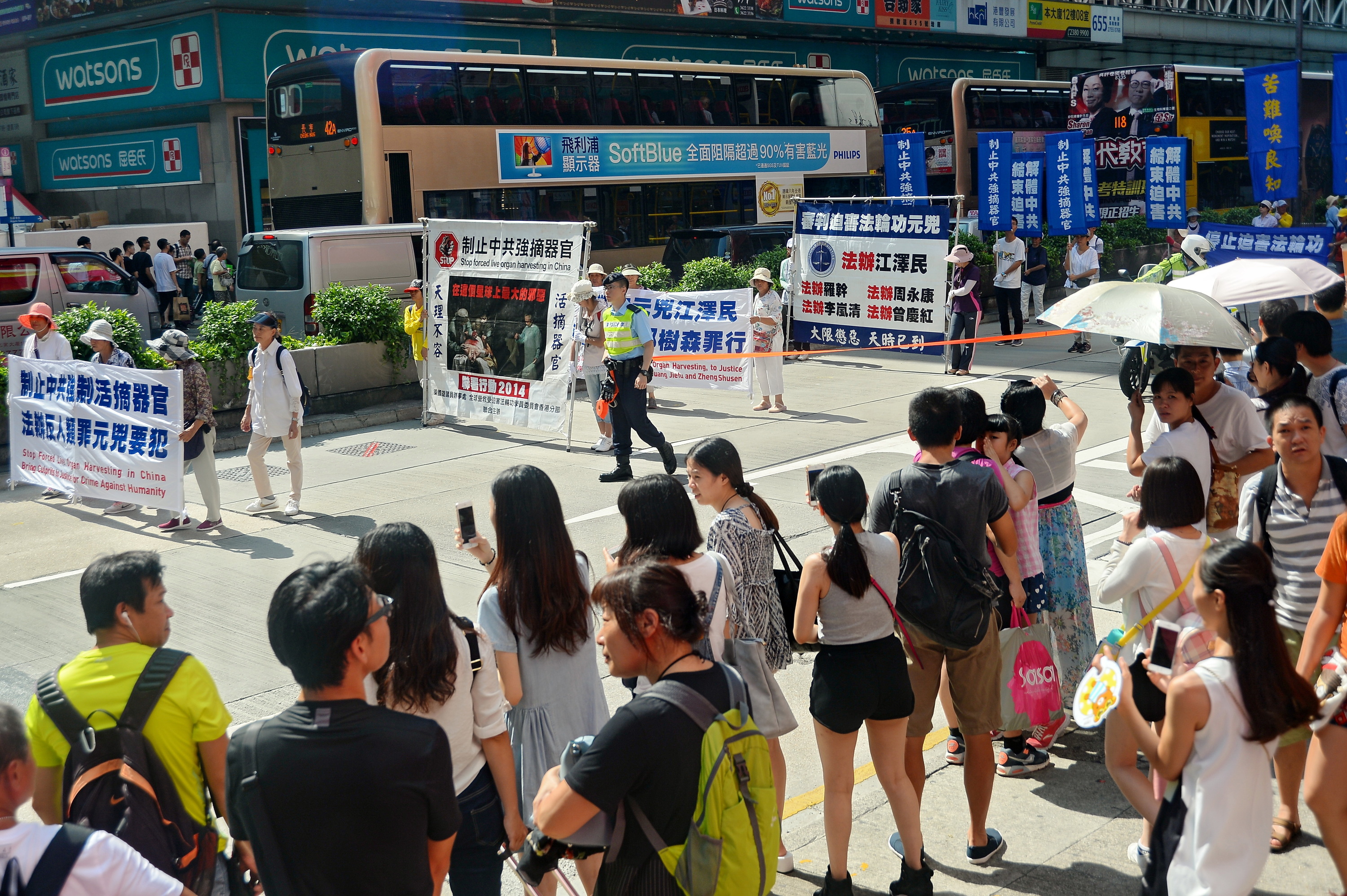 法輪功學員舉辦反對活摘遊行，在深水埗楓樹街球場開始遊行到尖沙咀，途中經過鬧區吸引許多民眾觀看。圖為集會中新唐人旗鼓隊表演。（宋祥龍/大紀元）