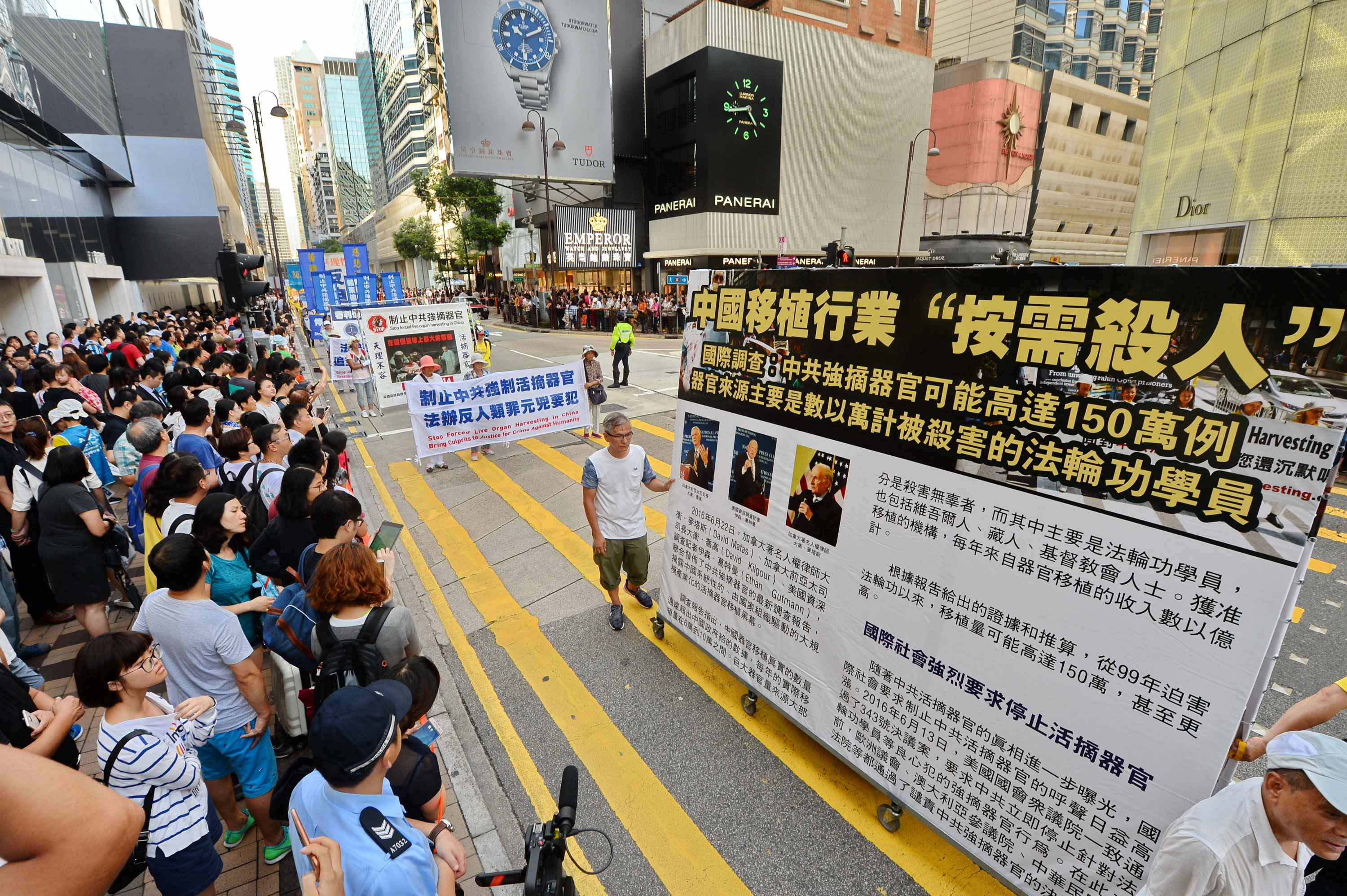 法輪功學員舉辦反對活摘遊行，在深水埗楓樹街球場開始遊行到尖沙咀，途中經過鬧區吸引許多民眾觀看。圖為集會中新唐人旗鼓隊表演。（宋祥龍/大紀元）