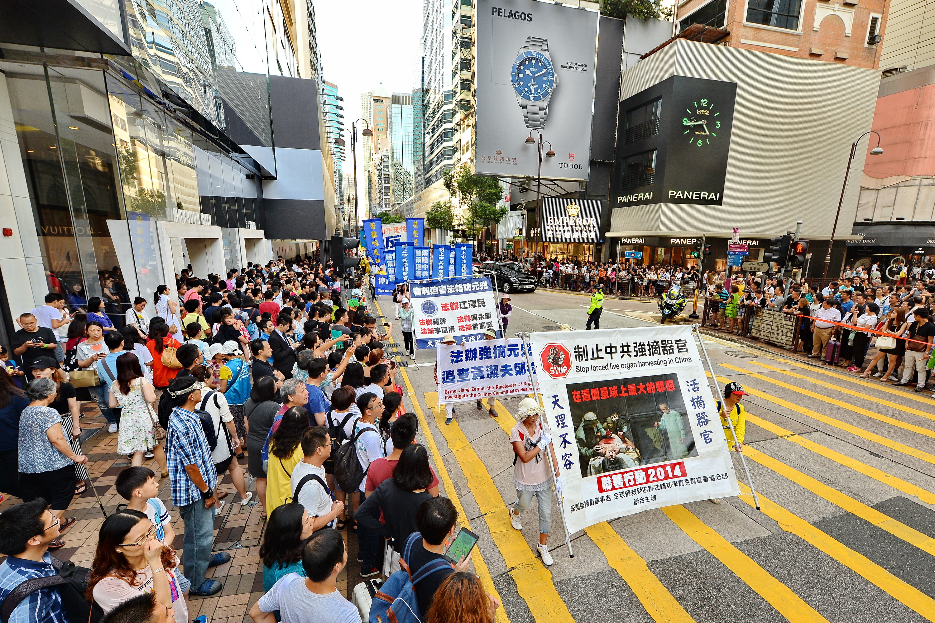 法輪功學員舉辦反對活摘遊行，在深水埗楓樹街球場開始遊行到尖沙咀，途中經過鬧區吸引許多民眾觀看。圖為集會中新唐人旗鼓隊表演。（宋祥龍/大紀元）