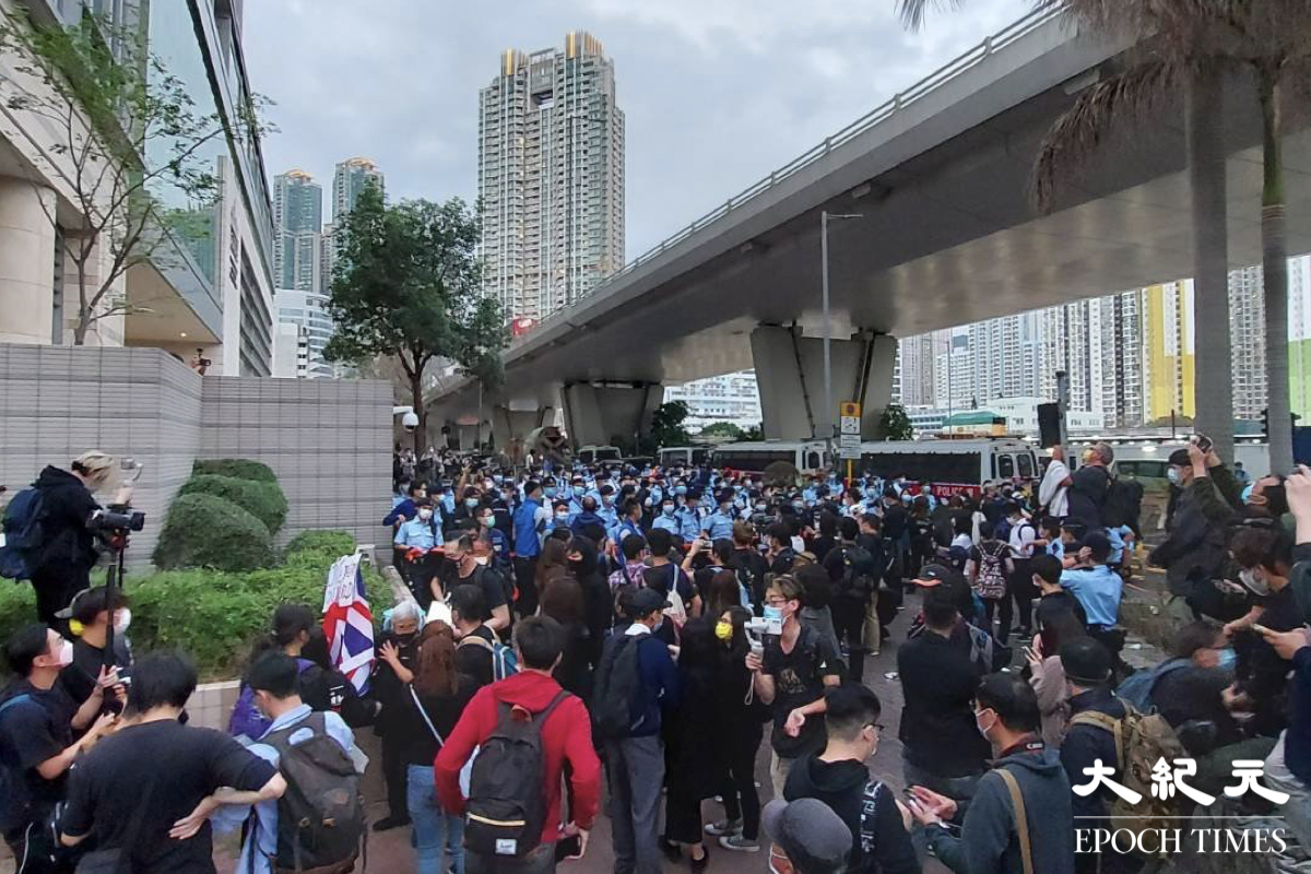 約60至70名機動部隊成員，突然由西九龍法院正門沼通州街，向旺角方向推進，驅散在法院門外守候的市民。（麥碧／大紀元）