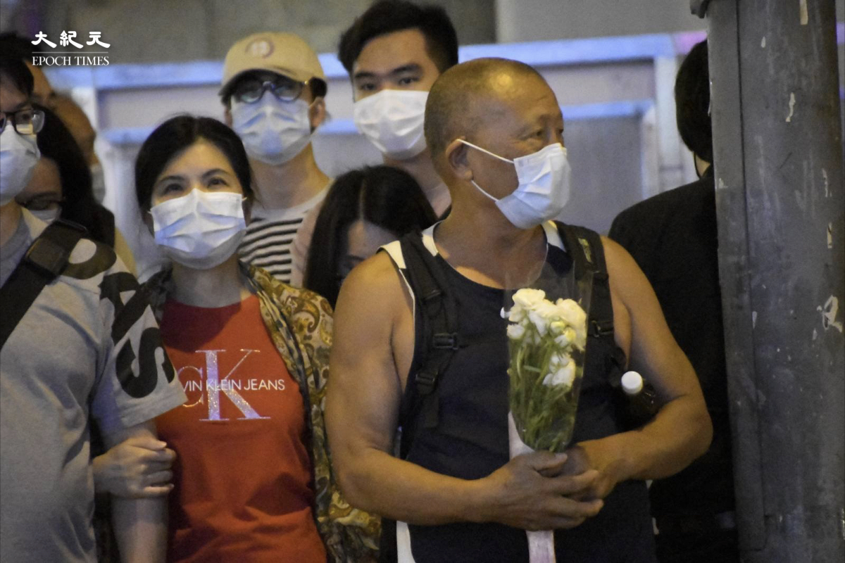 清明節前，多名市民手持鮮花到太子地鐵站外，靜默紀念19個月前發生的831恐怖襲擊事件。（麥碧/大紀元）