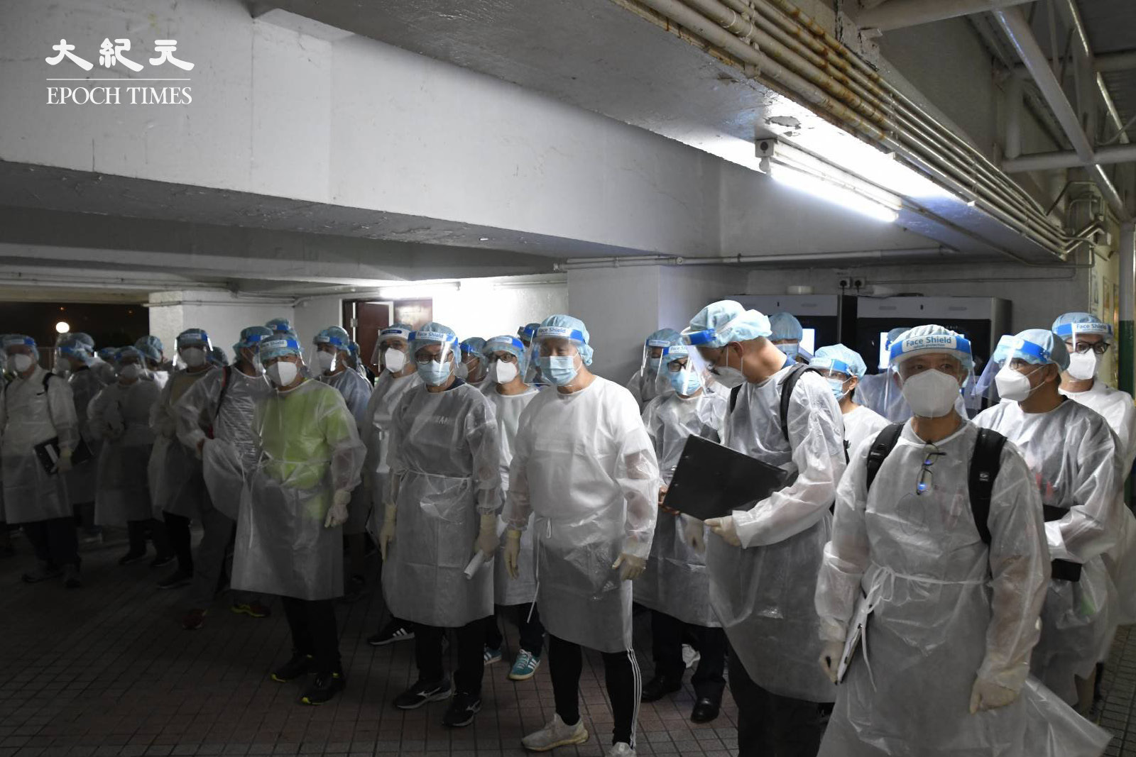 晚上8時半左右，大約50名穿著全套保護裝備的工作人員，到達荃威花園平台。（麥碧／大紀元）