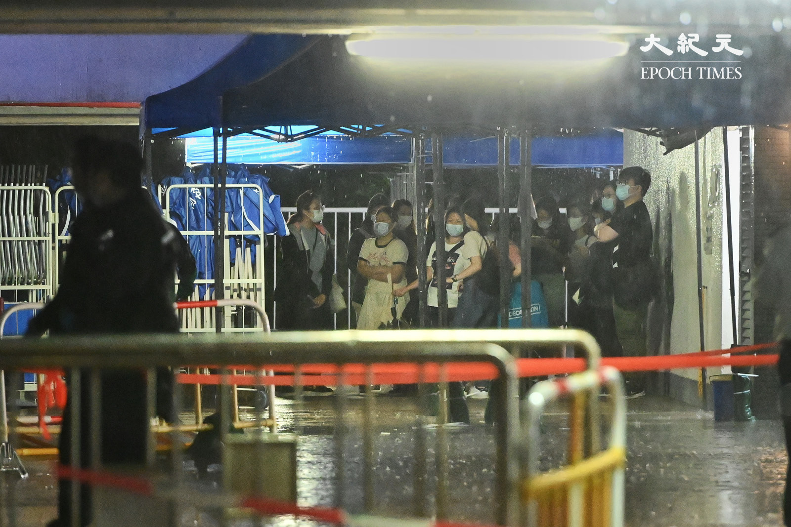 晚上9時，現場雨勢很大，強制檢測暫停，居民在帳篷裏等待強制檢測。（宋碧龍／大紀元）