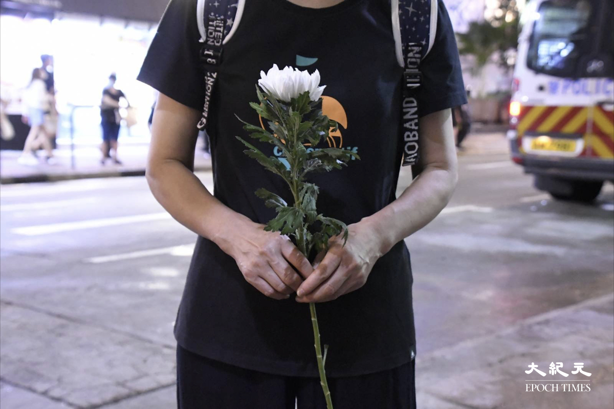 市民手持鮮花堅持悼念。（麥碧/大紀元）