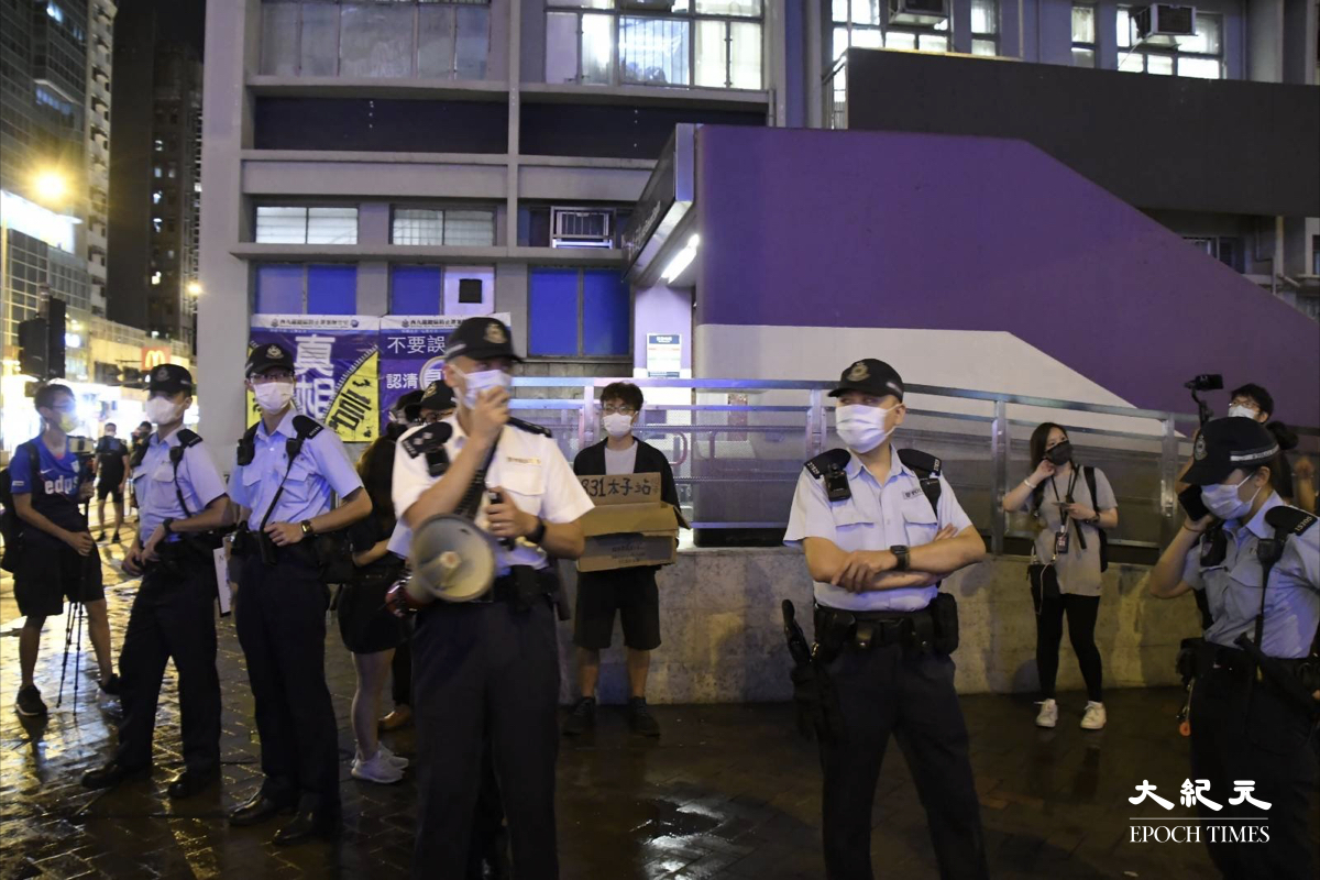 晚上9時10分，忽然有十多名警方機動部隊成員將候及其助理包圍。（麥碧/大紀元）