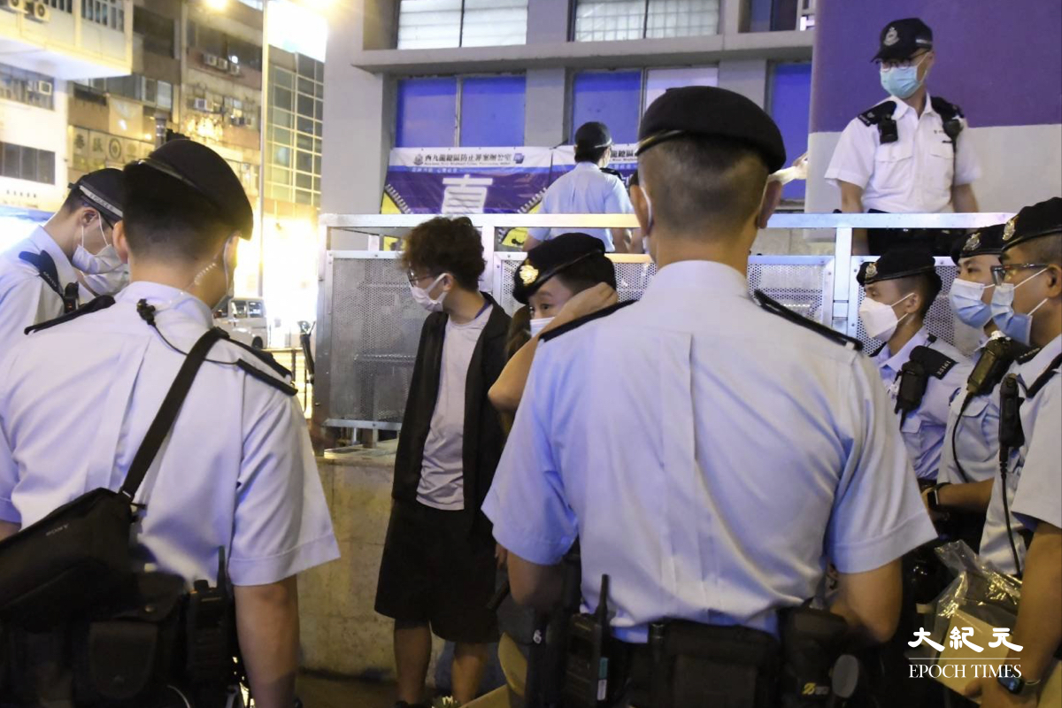 晚上9時10分，突然有十多名機動部隊成員將侯及其助理重重包圍。（麥碧/大紀元）