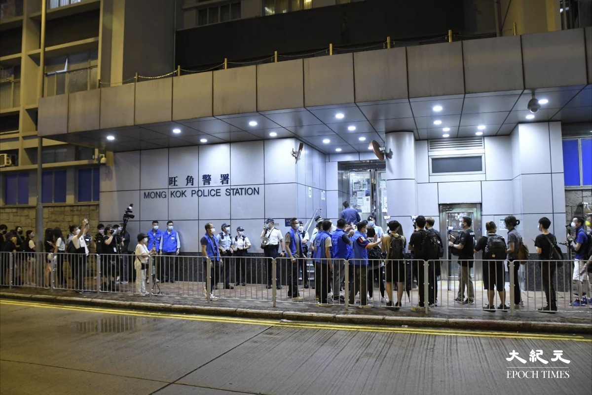 晚上9時15分，在場警方將候及其助理帶到旺角警署內，即時引來大批市民及傳媒在場圍觀。（麥碧/大紀元）