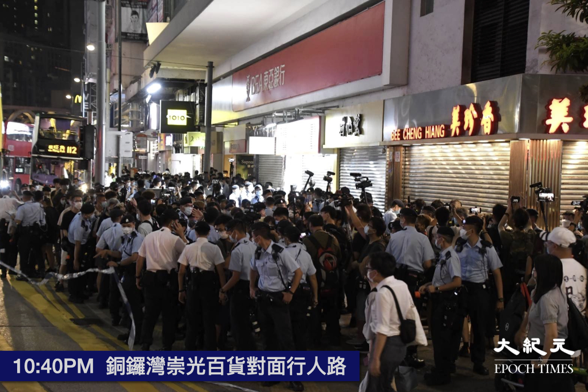 晚上10時40分，大約有30多名人士在崇光百貨對面行人路被截停搜查。 記者目測，在場警方人數超過100人。（麥碧／大紀元）