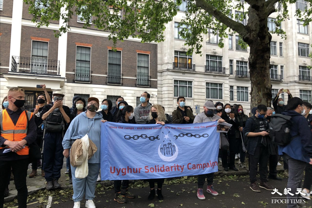 英國當地時間6月4日晚上約8時，中共駐倫敦總領事館對面聚集逾千人悼念六四。新疆人士拉起橫幅呼籲民眾關注。（文沁／大紀元）