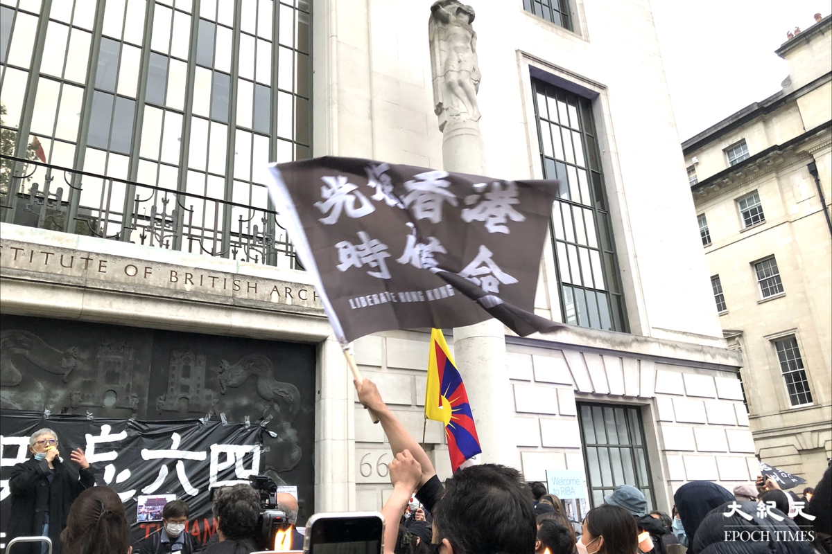 英國當地時間6月4日晚上約8時，中共駐倫敦總領事館對面聚集逾千人悼念六四。期間有港人手持蠟燭，揮動「光時」旗幟。（文沁／大紀元）