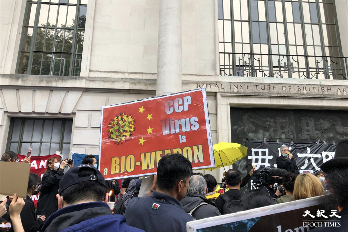 英國當地時間6月4日晚上約8時，中共駐倫敦總領事館對面聚集逾千人悼念六四。有人自製手標語牌譴責中共製造病毒。（文沁／大紀元）