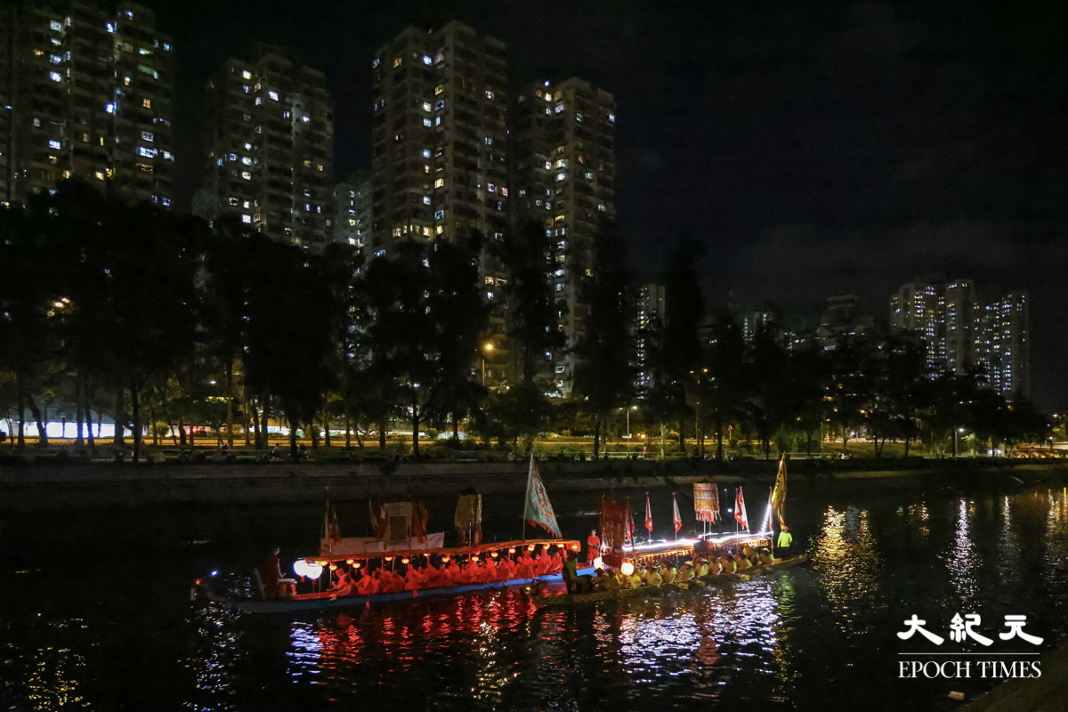 兩艘分別來自大埔鍾氏穎川堂及香港石氏宗親傳統夜龍總會的龍舟，亮起燈光來回在漆黑的林村河上巡遊。（陳仲明／大紀元）
