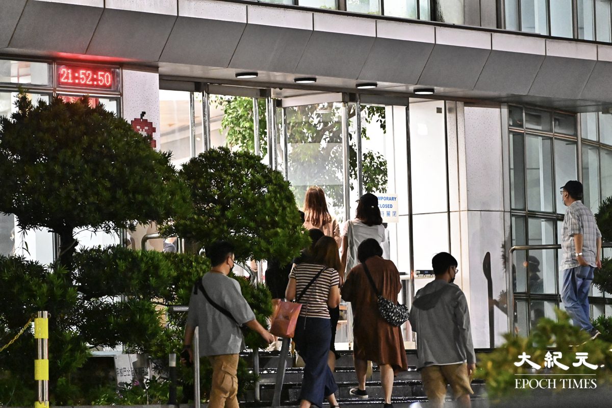 晚上近10時，蘋果廠房員工進入大樓上班。（宋碧龍／大紀元）