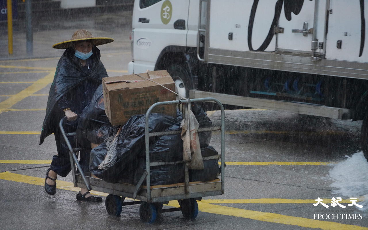 工人在雨中工作。（余鋼／大紀元）