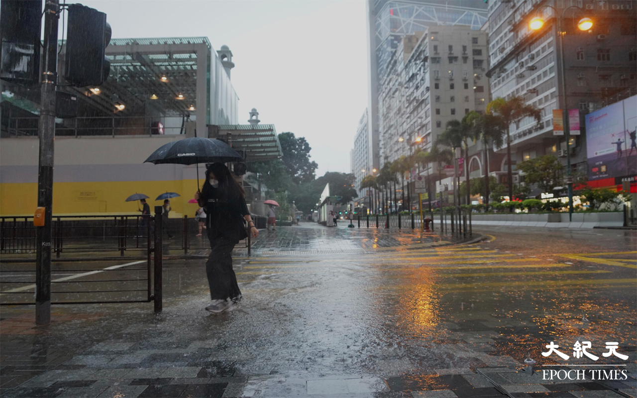 行人冒雨前行。（余鋼／大紀元）