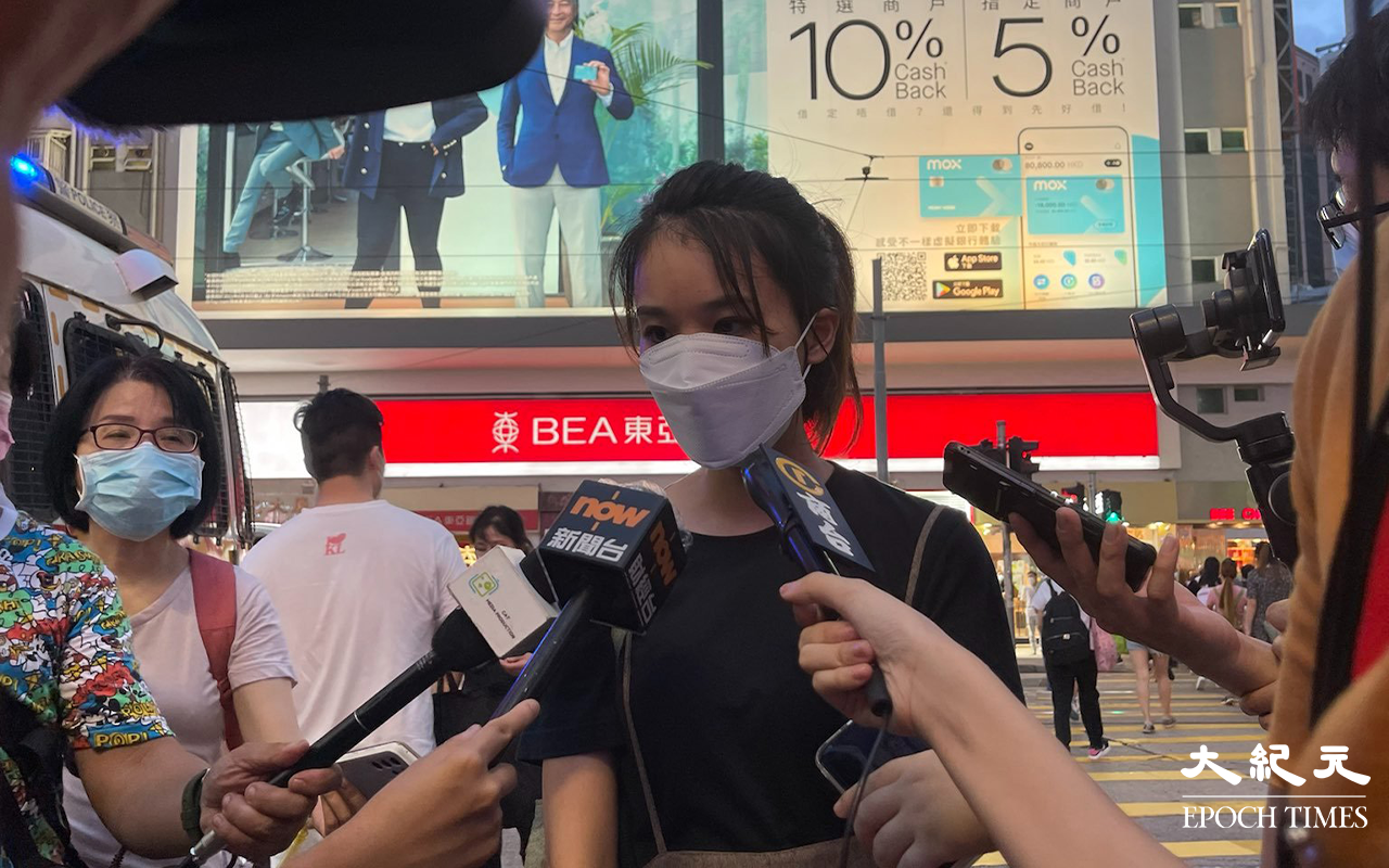 約七時三十分，有女子在Sogo對出馬路旁舉高一張寫有「永垂不朽，梁健輝先生安息，天佑香港。」隨後警員見狀立即上前圍封該女子及截查她身份。亦有兩名男子被截查後帶走上警車離開，未知拘捕原因。（李辰／大紀元）