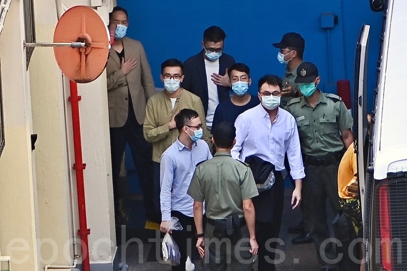 35名被告早上在荔枝角收押所被押上囚車放到法院，多人用手掩住心臟位置致意。圖為：王百羽、吳政亨、馮達浚、伍健偉和梁晃維（宋碧龍／大紀元）