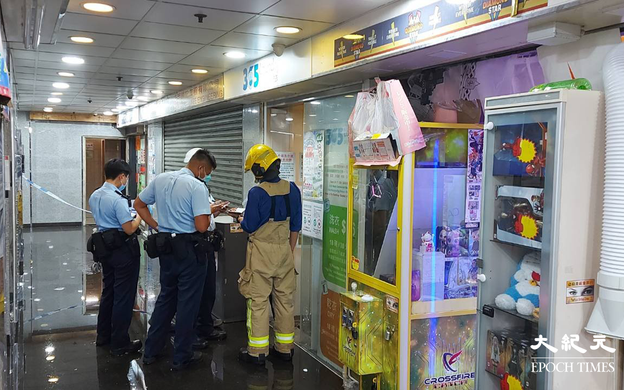 弼街金輪大廈內，自助洗衣店火警救熄後，警方及消防員調查起火原因。（麥碧 / 大紀元）