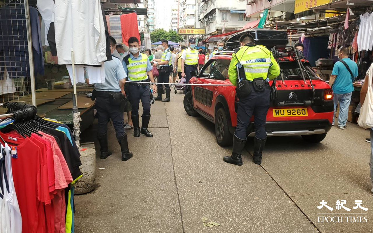 今日(14日）位於北河街99號對開，紅色私家車懷疑與途人發生碰撞，警員再次用碼尺量度確認距離。（米仔 / 大紀元）