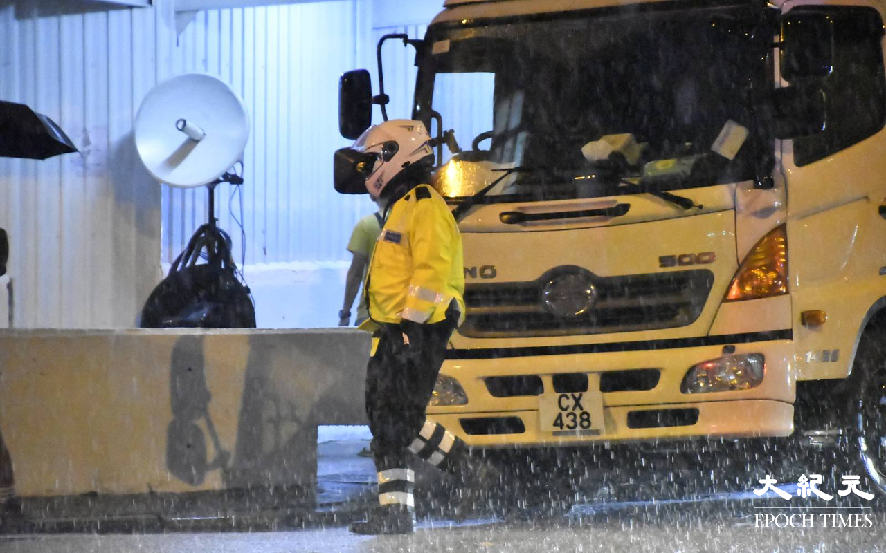 東盧大廈現場突然落起大雨，在場警方向傳媒透露，預計晚上8時開始圍封深水埗大埔道東廬大廈A座。（麥碧 / 大紀元）