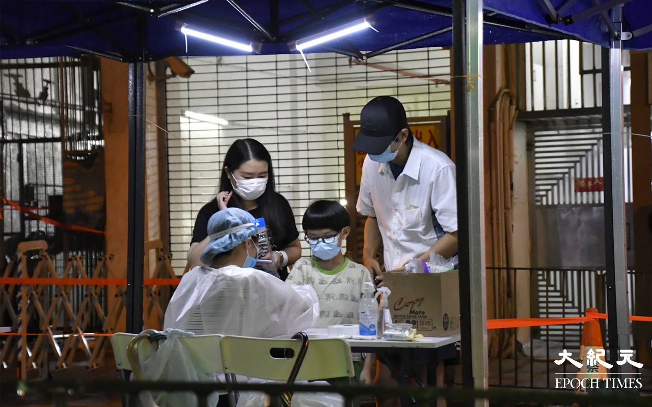 晚上9時許，陸續有東盧大廈居民，到樓下檢測站登記並戴上手帶。（麥碧 / 大紀元）