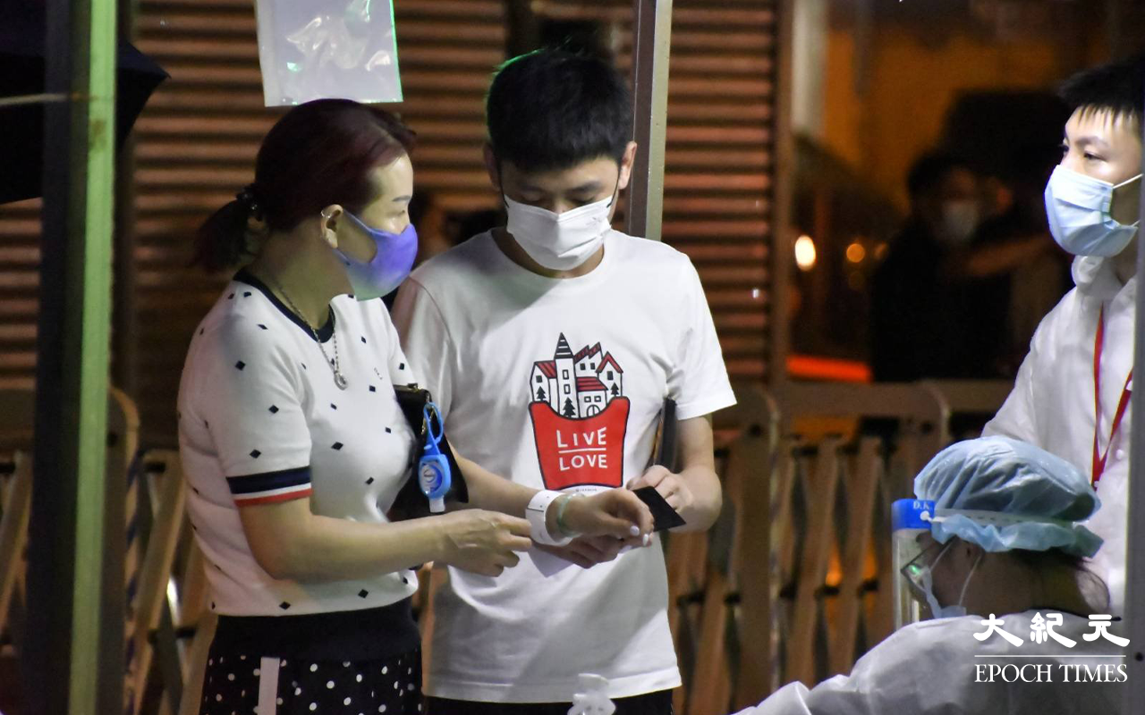 晚上9時許，陸續有東盧大廈居民，到樓下檢測站登記並戴上手帶。（麥碧 / 大紀元）