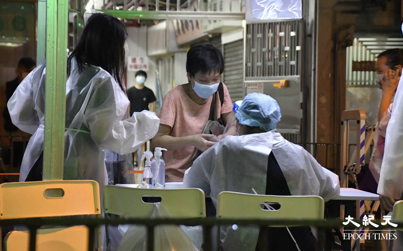 晚上9時許，陸續有東盧大廈居民，到樓下檢測站登記並戴上手帶。（麥碧 / 大紀元）