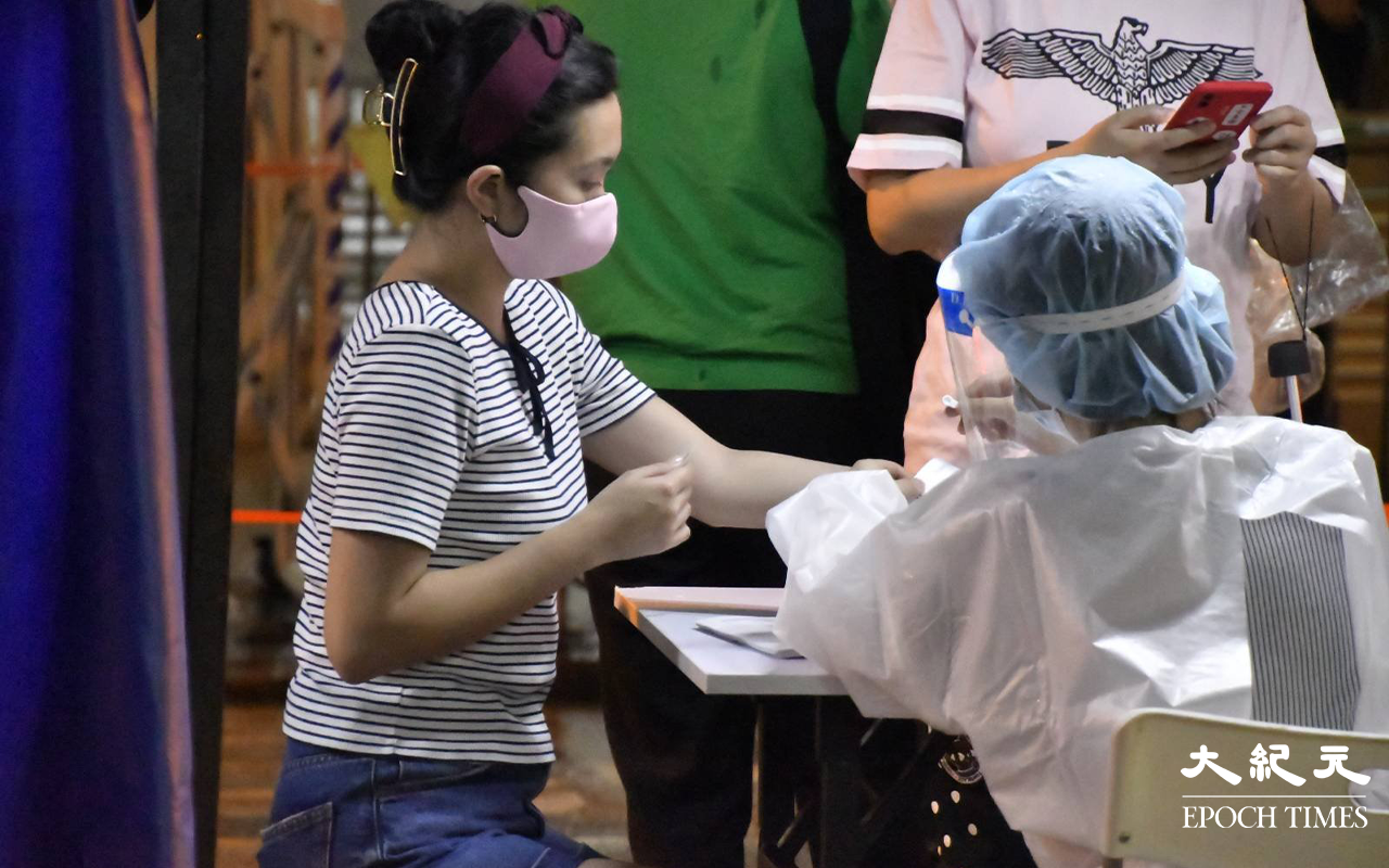晚上9時許，陸續有東盧大廈居民，到樓下檢測站登記並戴上手帶。（麥碧 / 大紀元）