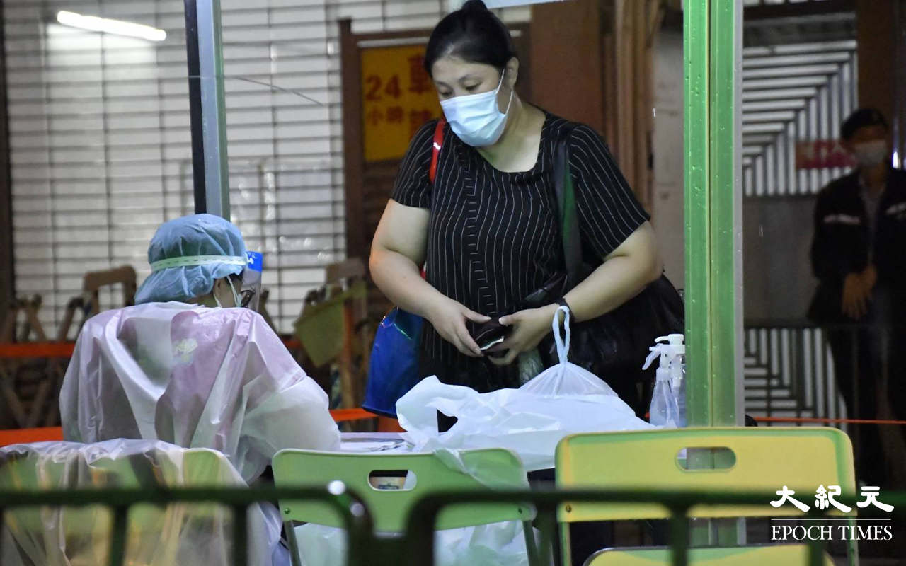 晚上9時許，陸續有東盧大廈居民，到樓下檢測站登記並戴上手帶。（麥碧 / 大紀元）