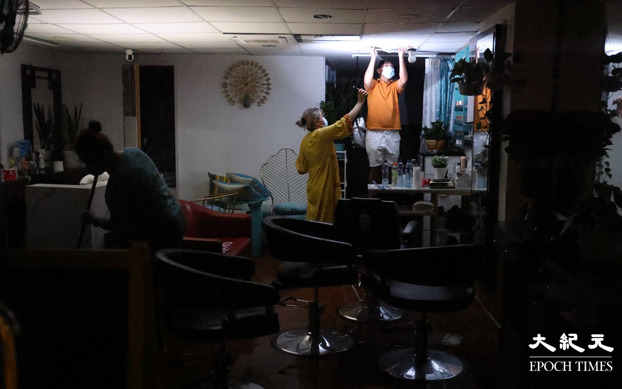 開設理髮店的尼泊爾籍人士，在火警救熄後清理現場。（李辰 / 大紀元）