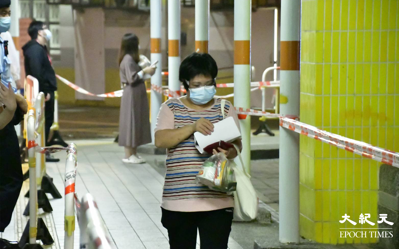 居民完成檢測，戴上可識別用的膠手帶，領取物之後離開檢測站。（麥碧／大紀元）