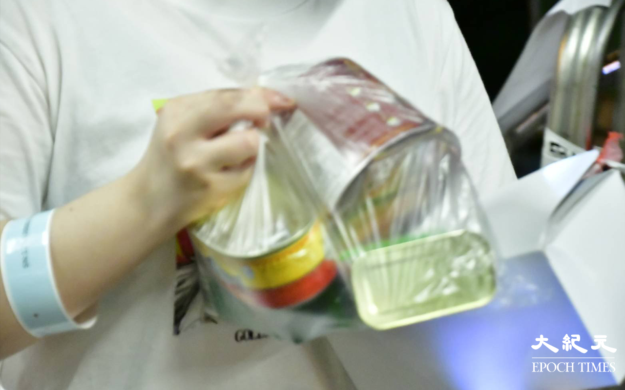 居民完成檢測，戴上可識別用的膠手帶，領取物之後離開檢測站。（麥碧／大紀元）