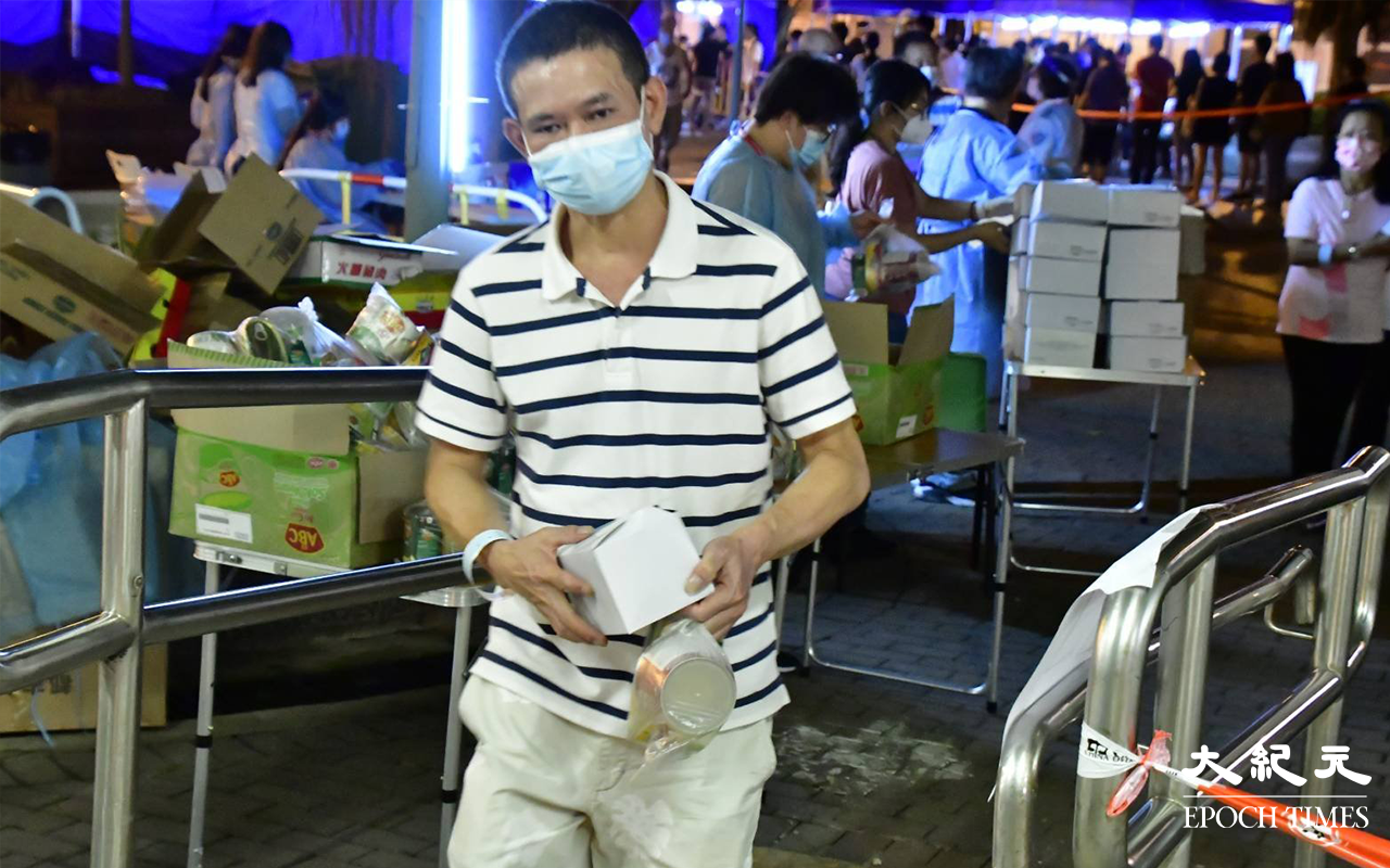 居民完成檢測，戴上可識別用的膠手帶，領取物之後離開檢測站。（麥碧／大紀元）