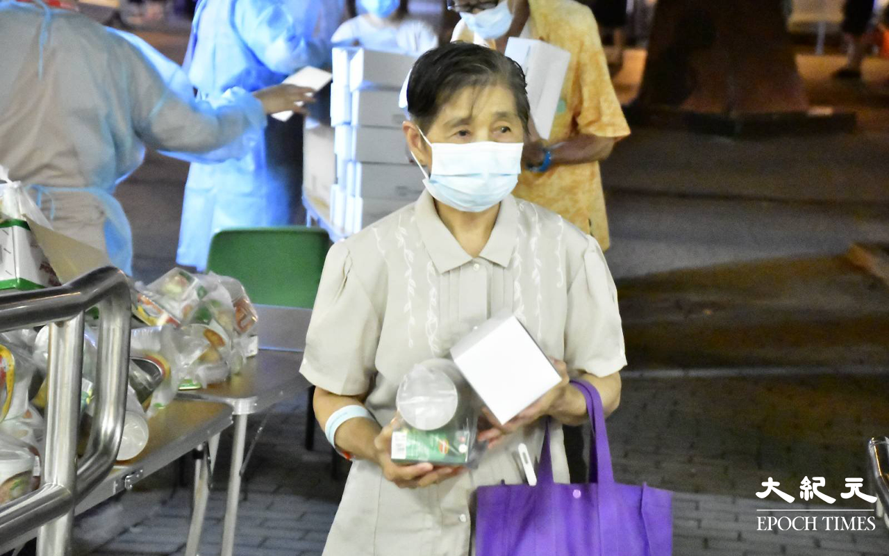 居民完成檢測，戴上可識別用的膠手帶，領取物之後離開檢測站。（麥碧／大紀元）