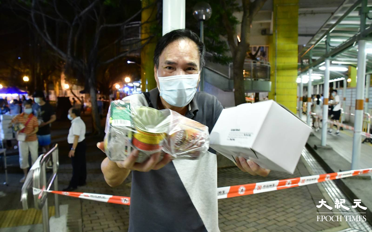 有位美逸樓居民領取物資後向記者展示物資，當記者問他心情如何時，他連番回答多謝。（麥碧／大紀元）