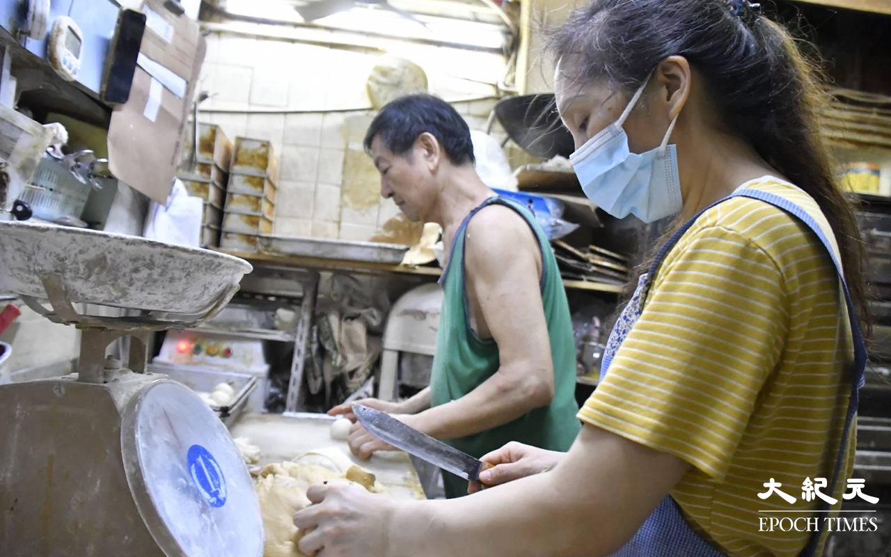 晚上接近10時，仍未食晚飯的「均香」老闆吳先生和兩位餅房員工，依然努力地為第二天早上出爐的菠蘿包及豬仔包做準備。（麥碧／大紀元）