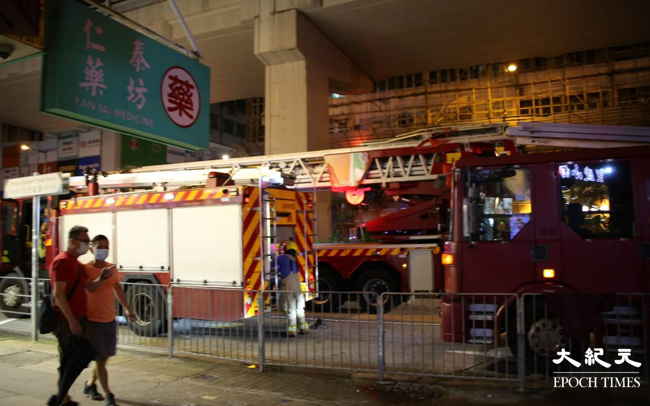 消防接報後，派出多輛消防車到現場戒備，亦派出多名煙帽隊及消防員進入大廈搜尋起火位置。（米仔／大紀元）