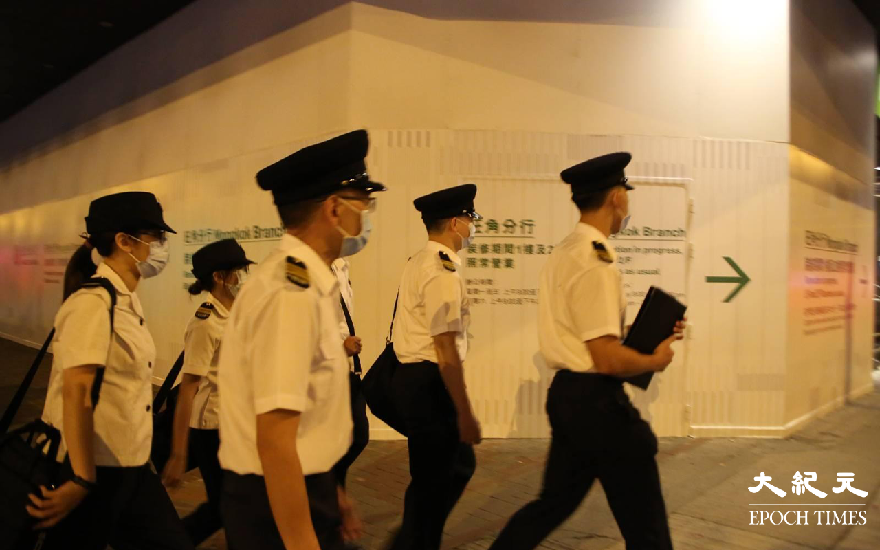 晚上約10時，大批便衣警察及食環署職員，突然掩至金山商業大廈17樓的一個單位。（Yan／大紀元）