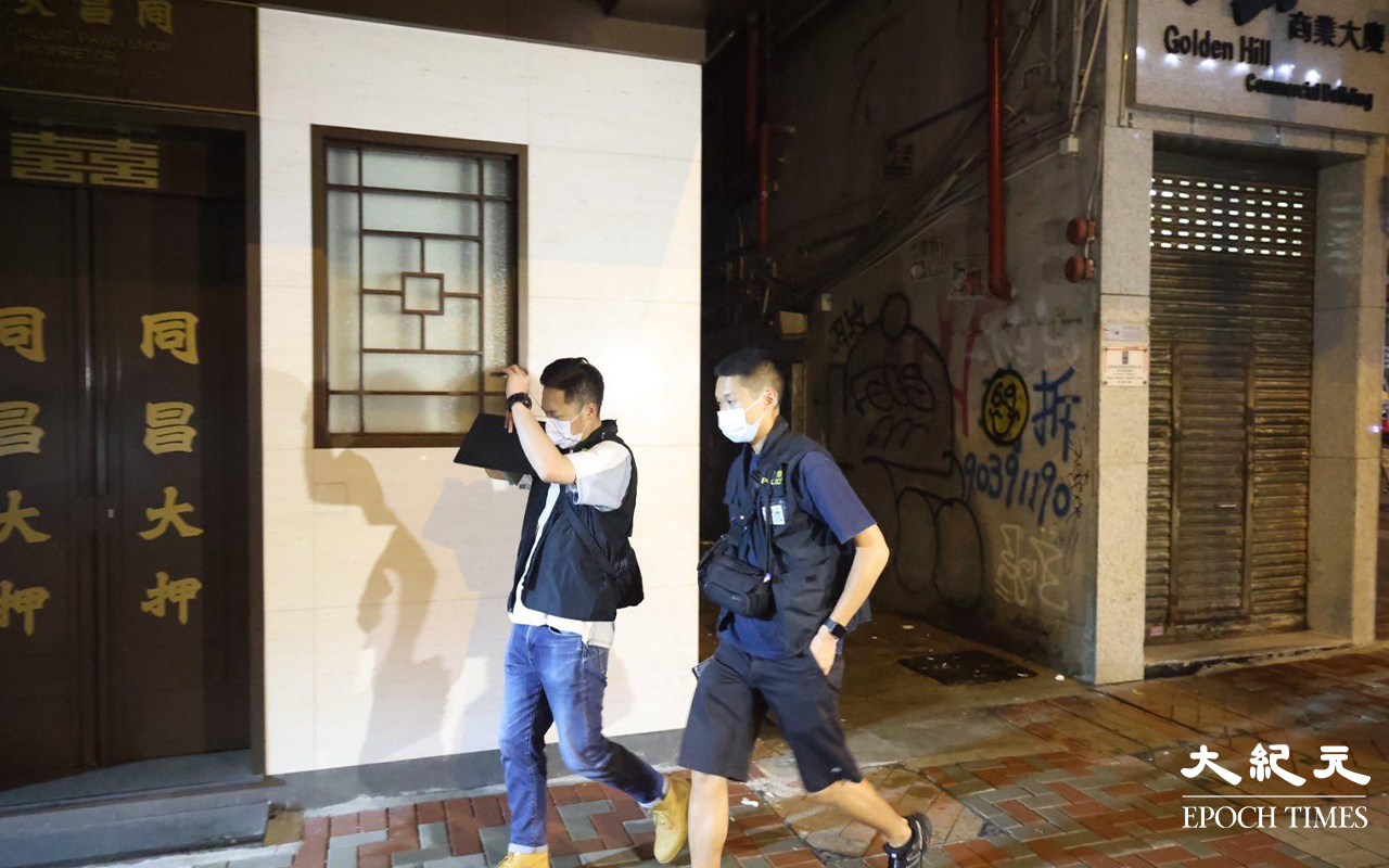 晚上約10時，大批便衣警察及食環署職員，突然掩至金山商業大廈17樓的一個單位。（米仔／大紀元）