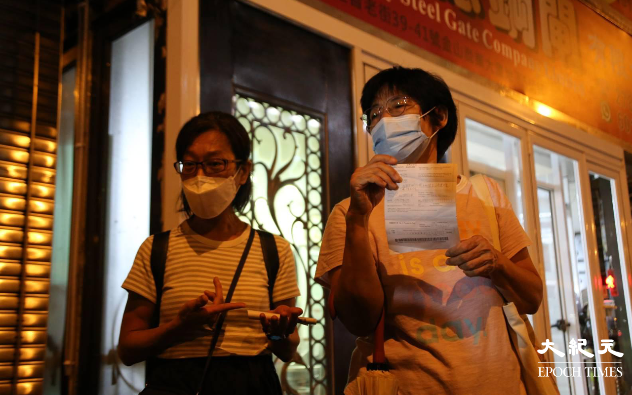 參與電影放映會後遭到票控的市民離開時，有部分市民拿著告票給記者拍照，有市民向記者表示無奈及不明所以。（李辰／大紀元）