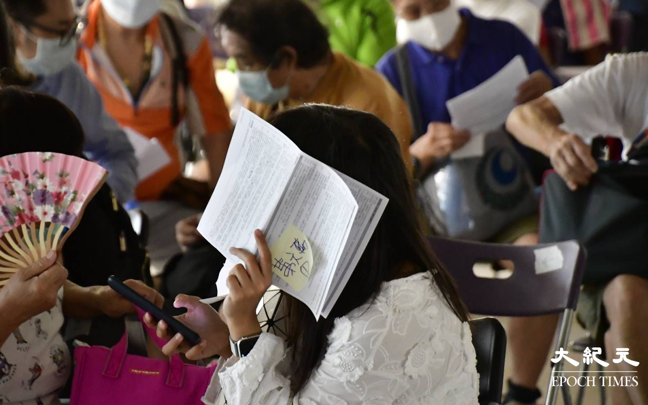 位於始創中心18樓，亦有數十名市民在排隊等候會見消費券秘書處主任，期間職員曾多次阻擋在場傳媒拍攝。（麥碧／大紀元）