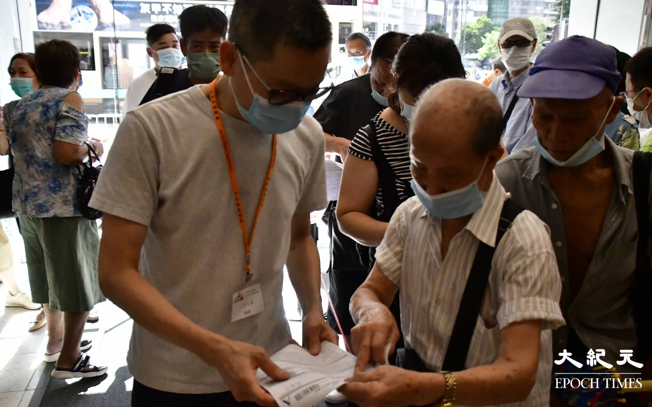 始創中心地下電梯大堂，下午仍不斷有市民排隊交表，記者發現大部分長者，皆對消費券申請表充滿疑問。（麥碧／大紀元）