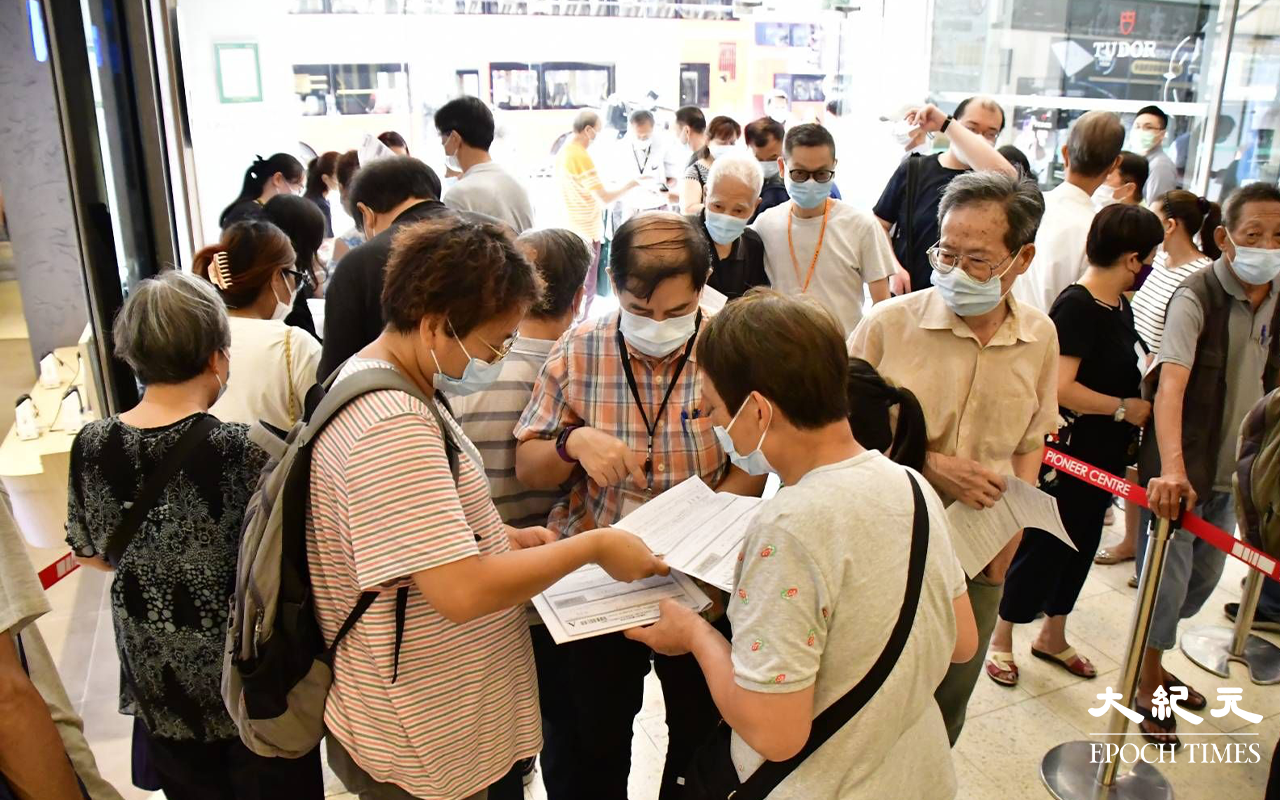 始創中心地下電梯大堂，下午仍不斷有市民排隊交表，記者發現大部分長者，皆對消費券申請表充滿疑問。（麥碧／大紀元）